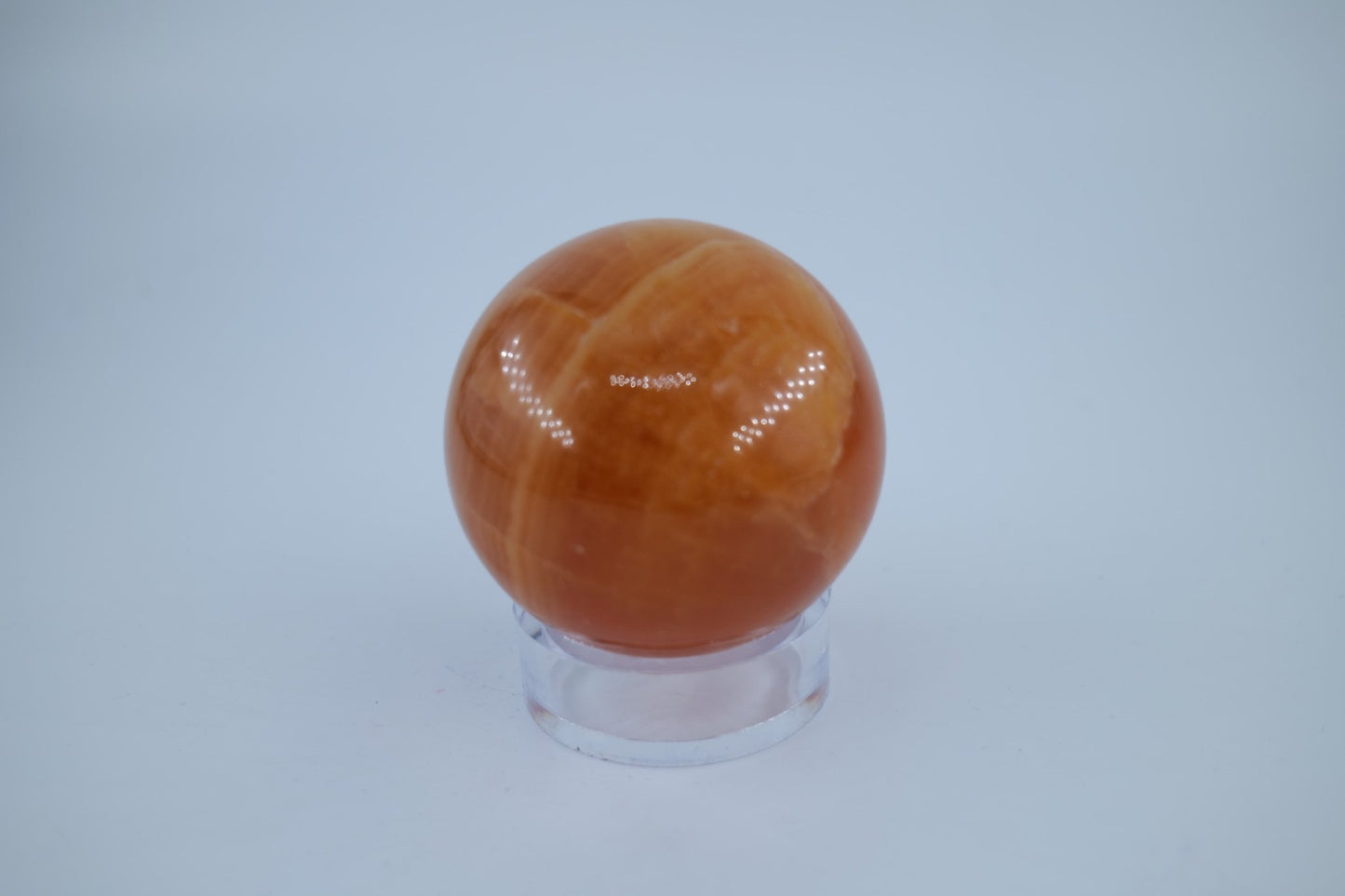 Polished Orange Calcite Sphere 316 grams featuring vivid orange tone and glassy sheen - Luna Panther