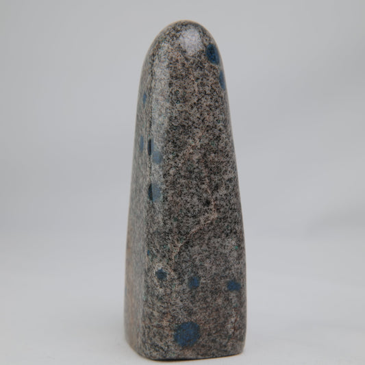 Angled K2 Jasper face showing blue spots across the grey-beige mineral matrix. alternate view