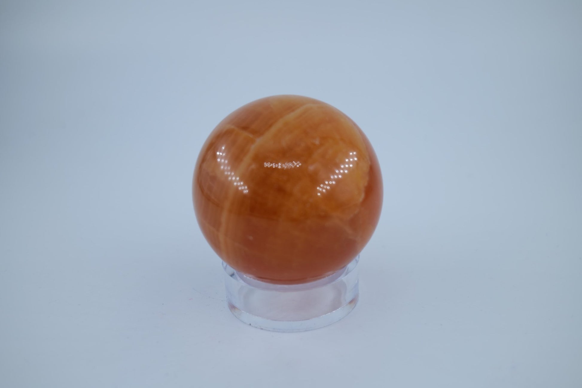 Polished Orange Calcite Sphere 316 grams featuring vivid orange tone and glassy sheen - Luna Panther