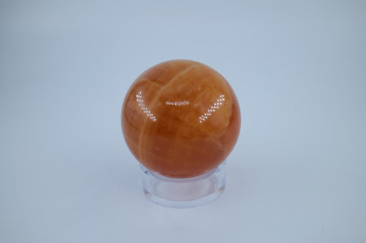 Polished Orange Calcite Sphere 316 grams featuring vivid orange tone and glassy sheen - Luna Panther