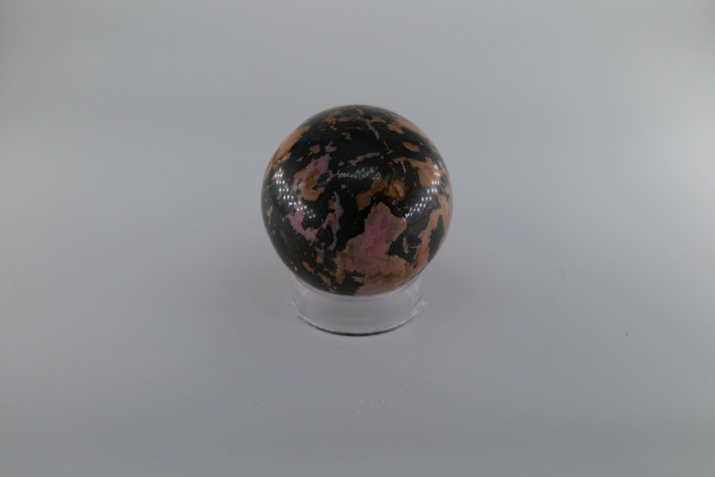 Polished Rhodonite Sphere 469 grams featuring pink tone with black veining - Luna Panther
