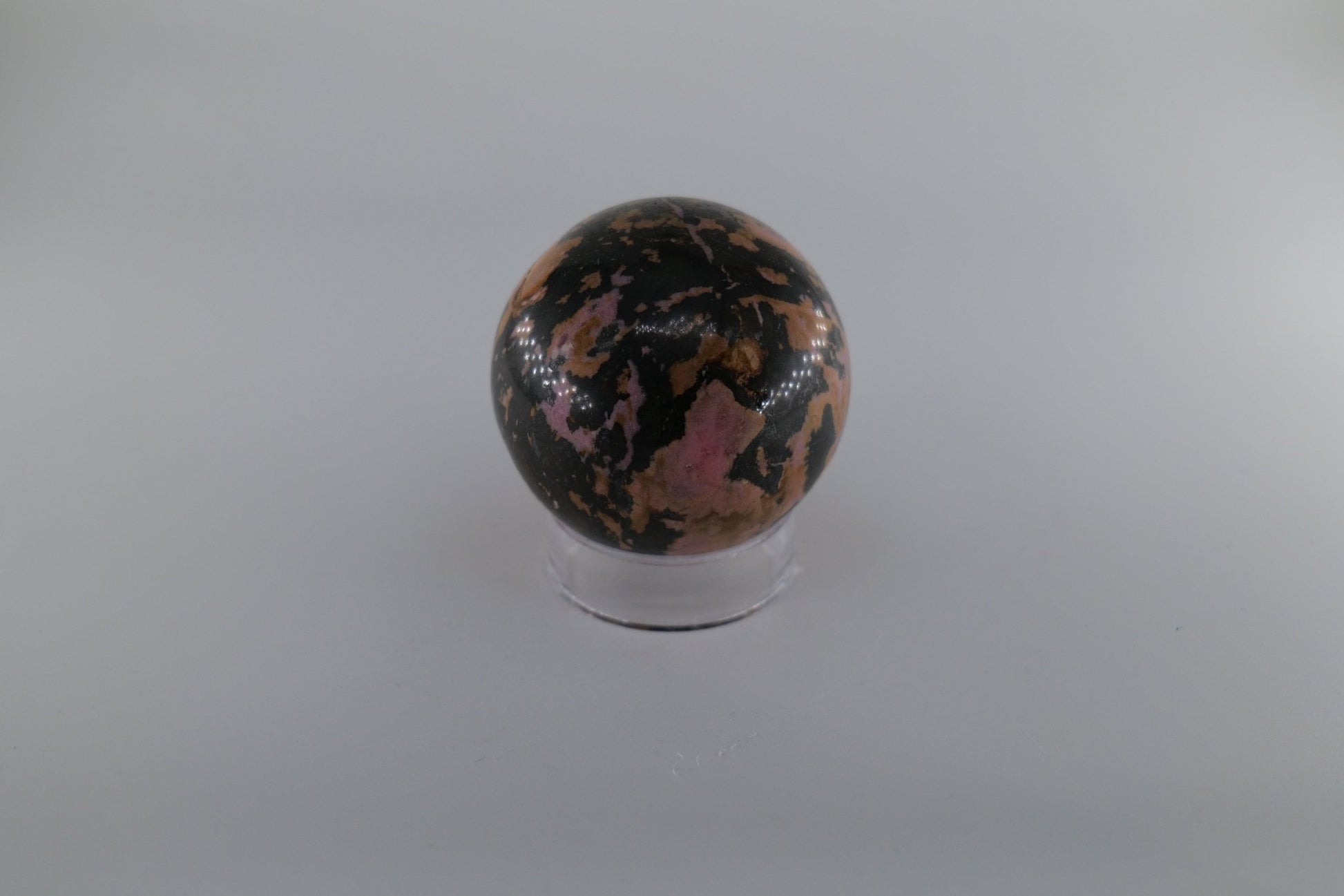 Polished Rhodonite Sphere 469 grams featuring pink tone with black veining - Luna Panther