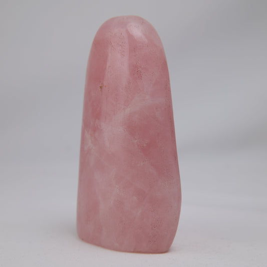 Narrow rose quartz face with pale cloudy veining running through the lower half. alternate view