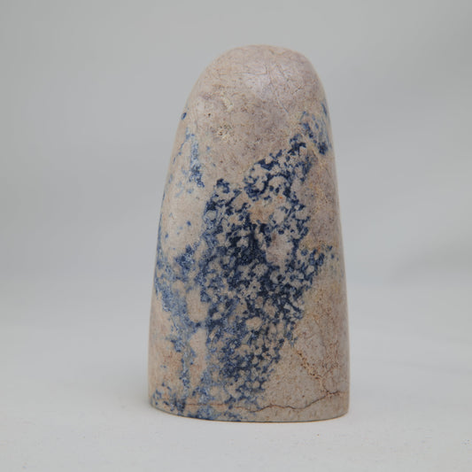 Broad pale feldspar face with a dense navy-blue patch running through the centre. alternate view